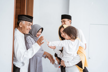 asian muslim aged couple meeting kids and grand children at doorstep during eid mubarakの写真素材