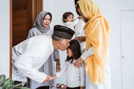 asian muslim aged couple meeting kids and grand children at doorstep during eid mubarakの写真素材
