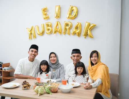 asian muslim family looking at camera celebrate eid mubarakの写真素材