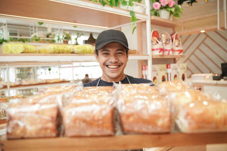 handsome asian smiling worker at the bakery shopの写真素材