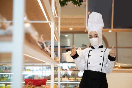 woman bakery restaurant owner open for business wearing a mask for a protection against virusの写真素材