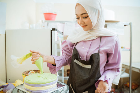 beautiful young baker making cake at her kitchen