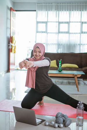 muslim woman doing gymnastics at homeの写真素材
