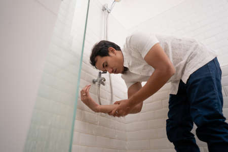 portrait of young Muslim man perform ablution (wudhu) before prayer at homeの写真素材