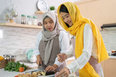 beautiful two muslim woman enjoy cooking dinner together for iftar breaking the fast on ramadan in the kitchenの写真素材