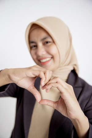 close up hand woman entrepreneur wearing hijab love sign hand pose, office work concept isolated white backgroundの写真素材
