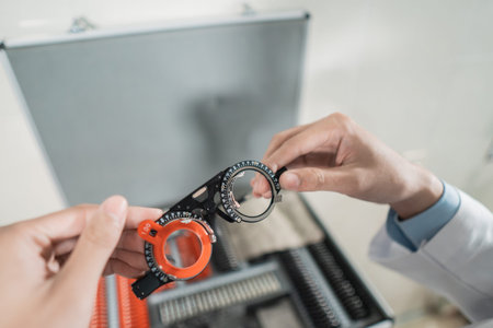 a doctors hand is holding the experimental lens frame in a room in an eye clinic with the background...