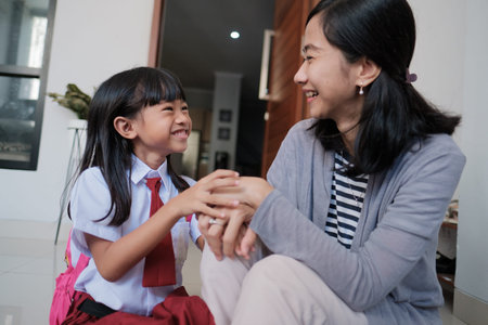 happy primary student at back home after school and talk to her mother
