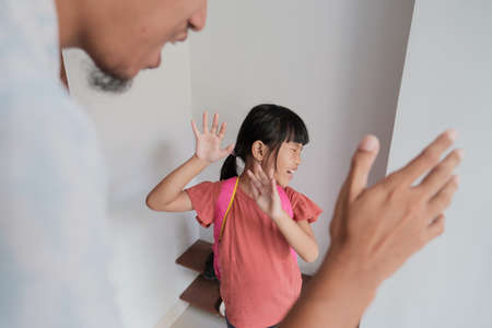 abusive parent try to hit his kid at home. father and daughter domestic violenceの写真素材