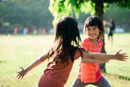 two Asian girl is stretching exercise in the park in the morningの写真素材