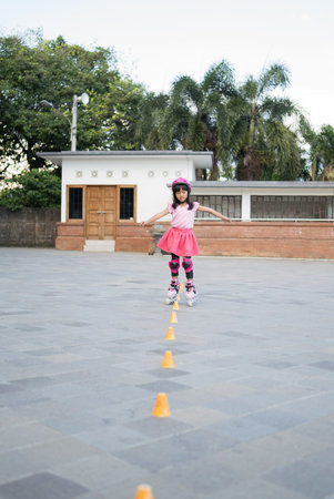 smiling 5 year old asian girl going on her in-line skatesの写真素材