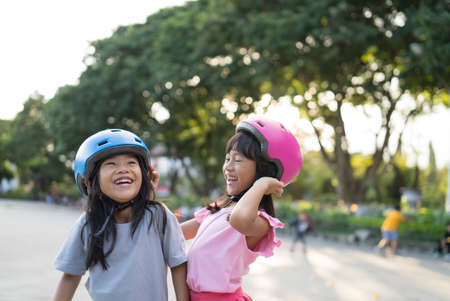 two asian girl going on her in-line skates in the parkの写真素材