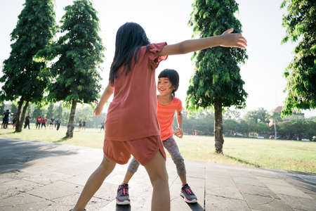 asian kid catch and play together outdoor with friendの写真素材