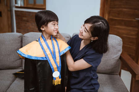 Kindergarten graduation. Asian family and parent on her kid kinder graduate day.の写真素材