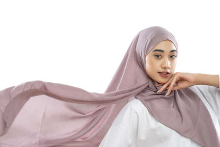 hijab woman wearing purple veil dress waving in the wind on white backgroundの写真素材