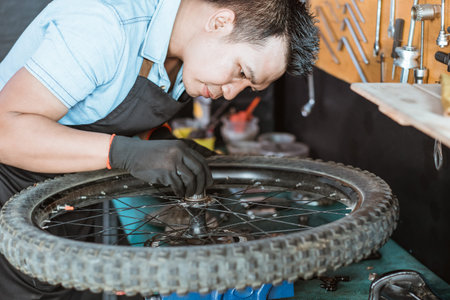 a mechanic wearing an apron and gloves installs a spacer on the hub shell