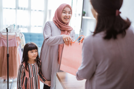 mother and kid shopping in the mall buying some clothes