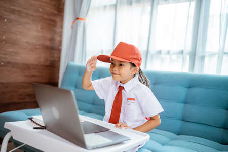 asian primary school student with uniform giving saluteの写真素材