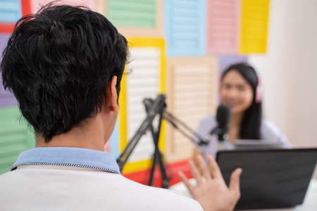 back view of man chatting with woman during podcastの写真素材