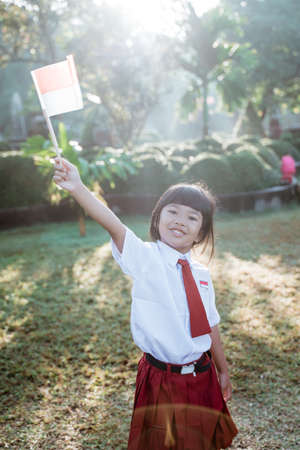 indonesian school student holding flag during independence day.の写真素材