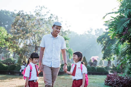father walk her child to school in the morningの写真素材