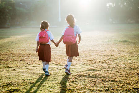 two girl friend primary school student walking togetherの写真素材