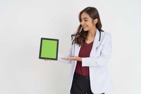 a female doctor with a gesture presenting something while showing the screen of a pad to the cameraの写真素材
