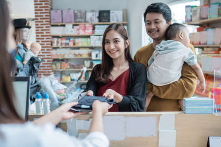 family making a payment at the baby shop using credit card at the cashierの写真素材