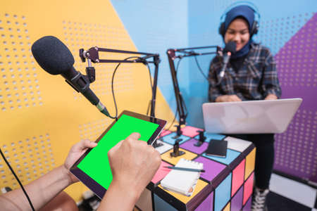 muslim asian woman and man talking on podcast studio togetherの写真素材