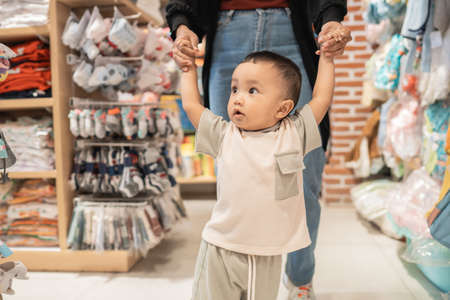 boy learn to walk while shopping in baby storeの写真素材
