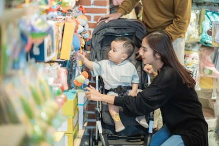 asian mother with her toddler boy shopping in the baby shopの写真素材
