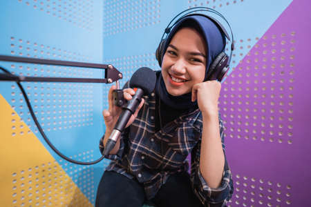 A vlogger girl is recording a podcast in studioの写真素材