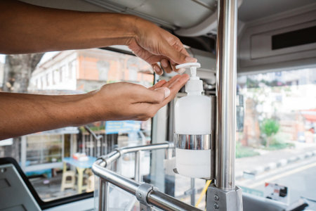 hands wash with an automatic sanitizer dispenser in public transport