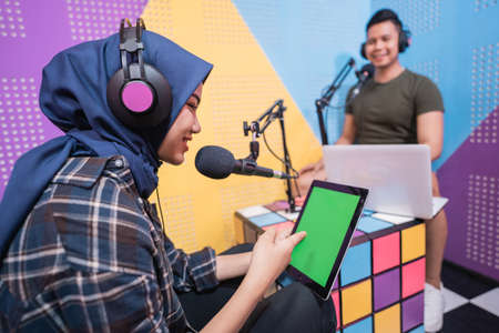 muslim asian woman and man talking on podcast studio togetherの写真素材