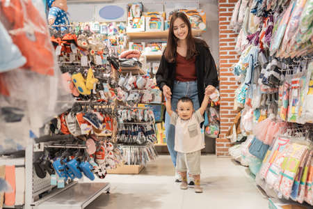 boy learn to walk while shopping in baby storeの写真素材