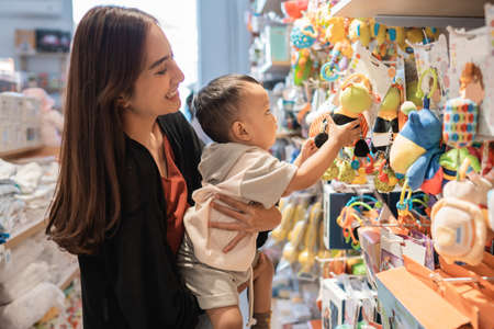 mother take her 1 year old son to buy toysの写真素材