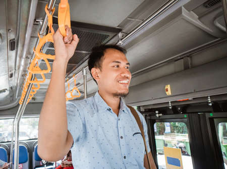 Young modern businessman employee in public transport.の写真素材