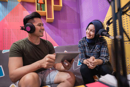 man and woman during live interview in podcast studio togetherの写真素材