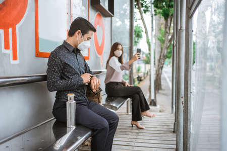 male and female worker looking at his watchの写真素材
