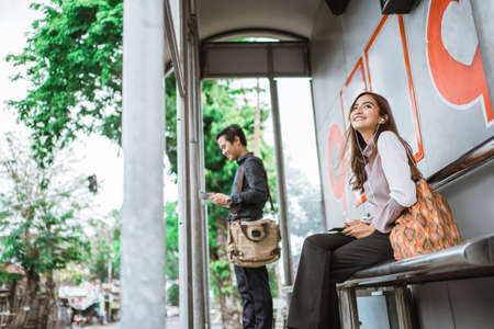 attractive young asian woman waiting for public transportの写真素材