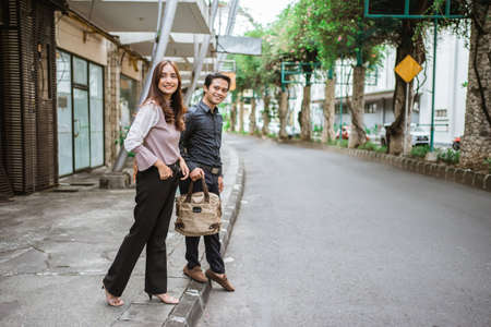 Business man and woman walking trough sidewalk smiling going to officeの写真素材