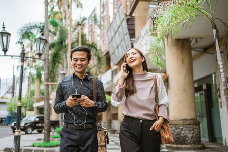 Business people walking trough sidewalk and using phoneの写真素材