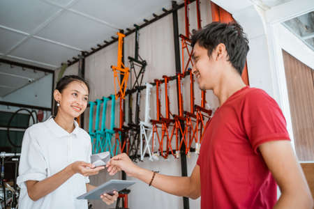 customer paying with credit card while buying a bicycleの写真素材