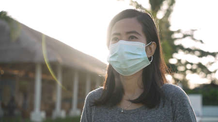 Asian woman putting on a medical disposable mask to avoid viruses.の写真素材