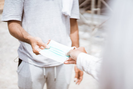 gesture of hand giving a mask to someone
