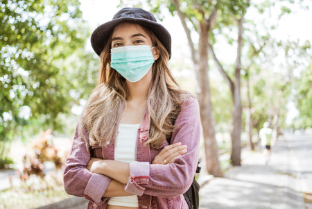 Asian woman putting on a medical disposable mask to avoid viruses.