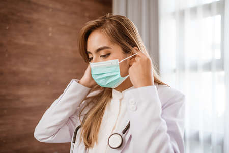 woman doctor wearing medical mask standing looking at cameraの写真素材