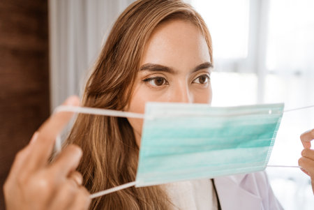woman doctor wearing medical mask standing looking at cameraの写真素材