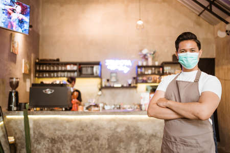 Waitress wearing a face mask at the coffee shopの写真素材