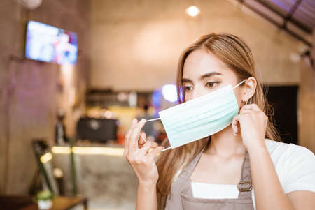 Waitress wearing a face mask at the coffee shopの写真素材